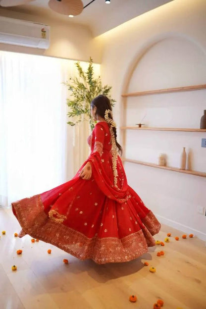 Designer red ethnic gown featuring golden embroidery and a flared skirt