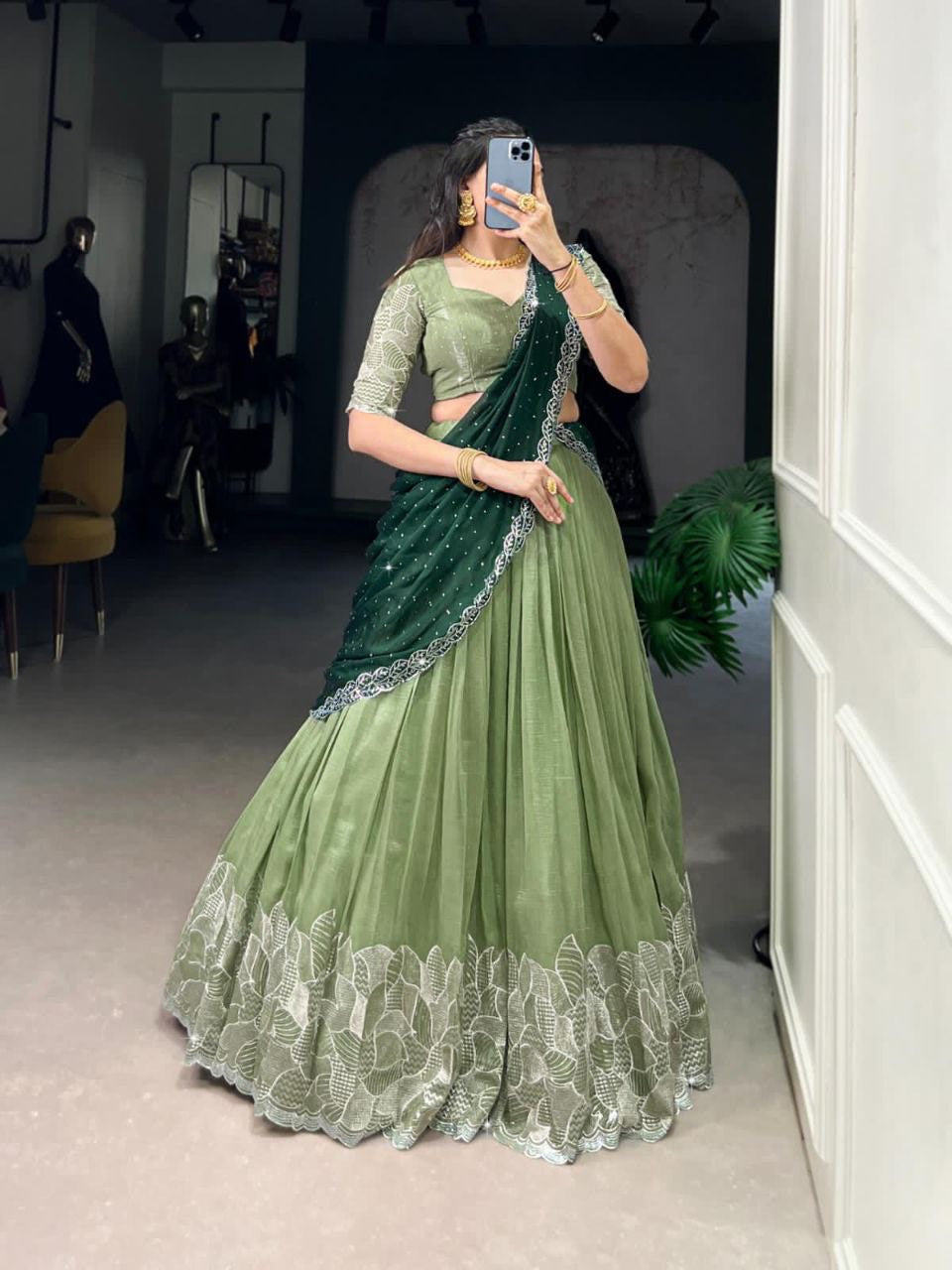 Beautiful partywear green lehenga featuring floral embroidery and a contrasting dark green pallu.