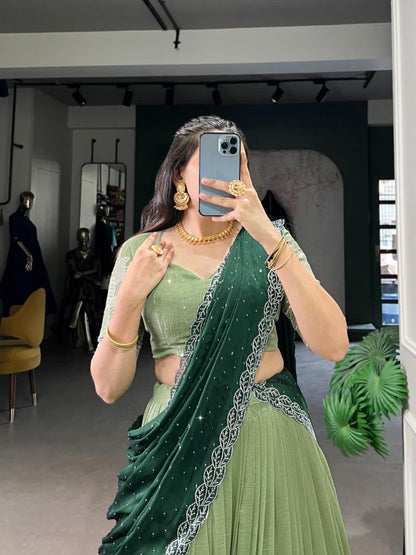 Graceful olive green ethnic outfit with detailed embroidery, gold jewelry, and contemporary draping style.